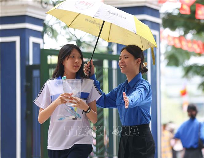Tình nguyên viên tại điểm thiTrường THPT Trần Nhân Tông nhiệt tình đón các thí sinh tới thi môn Ngoại ngữ. Ảnh: Thanh Tùng - TTXVN
